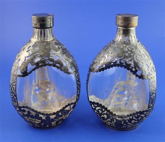 A pair of late 19th/early 20th century Chinese silver overlaid dimpled moulded glass decanters and lids, 8in.